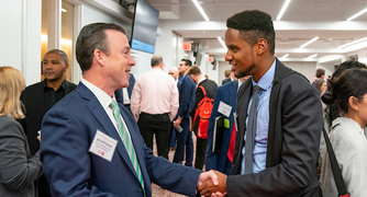 Image of student networking with alumnus.